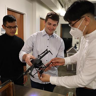 Engineering students examine a drone