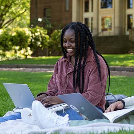 An SPU student works on her laptop in Tiffany Loop
