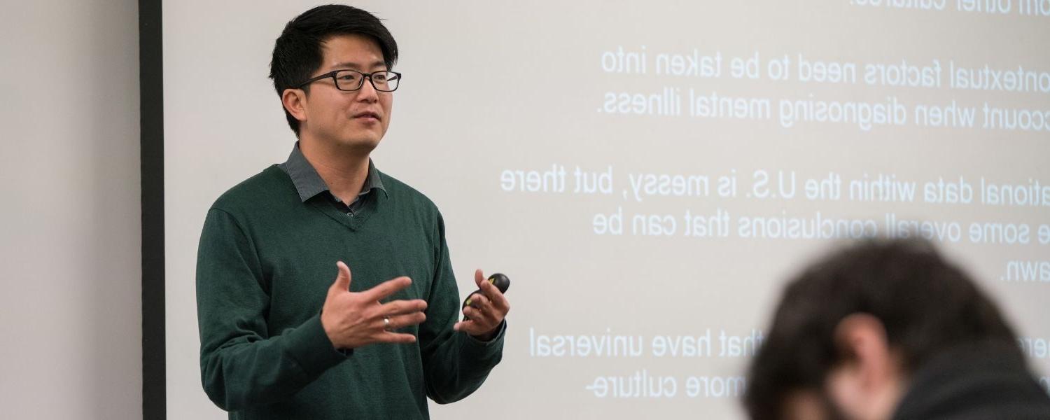 Professor of Psychology Paul Kim teaches in front of a classroom, facing his students and with his back to a whiteboard.